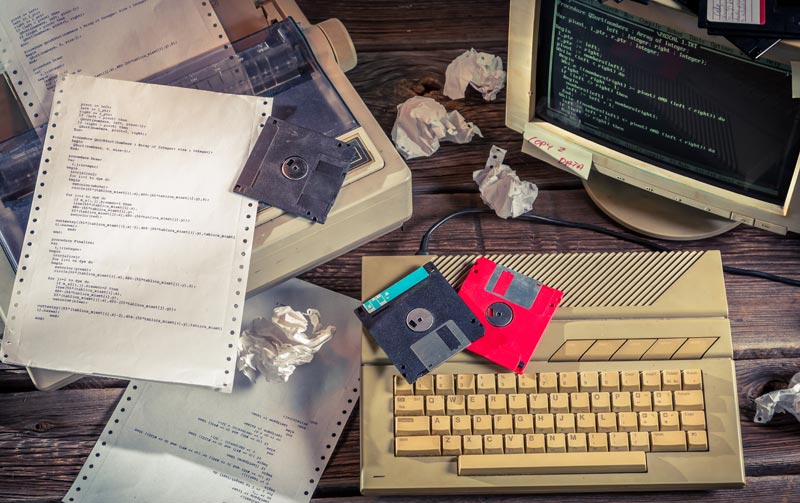 Digital-Marketing: Die nackte Wahrheit nach 25 Jahren an der Front 1 Nostalgischer Arbeitsplatz mit einem alten Röhrenmonitor, Disketten, zerknittertem Papier und Programmiercode; Symbol für die Anfänge der Digitalisierung.
(c) AdobeStock