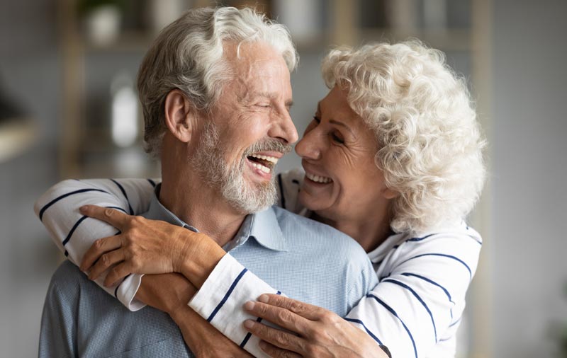 Die ultimative Migräne-Checkliste: Ihr Wegweiser aus dem Schmerzlabyrinth 2 Ein älteres Ehepaar mit grauen Haaren lacht ausgelassen. Die Frau umarmt den Mann von hinten, beide strahlen pure Lebensfreude und Vitalität aus. Fokus: Schmerzfreiheit und Lebensqualität durch Migräne-Therapie, Stichwort Migräne-Checkliste.
(c) AdobeStock