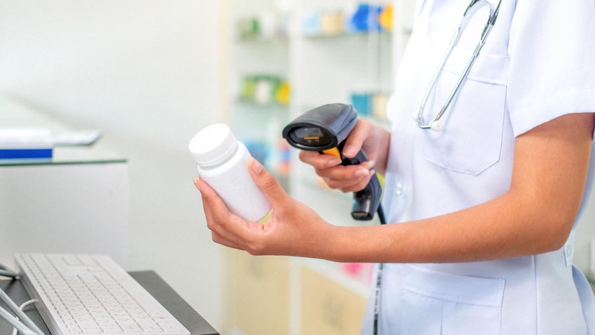 Kundenbindung: Das E-Rezept als Fundament der modernen Apothekenführung E-Rezept Österreich: Eine Pharmazeutin scannt mit einem Barcode-Scanner eine Medikamentenflasche an der modernen Apotheken-Tara. (c) AdobeStock