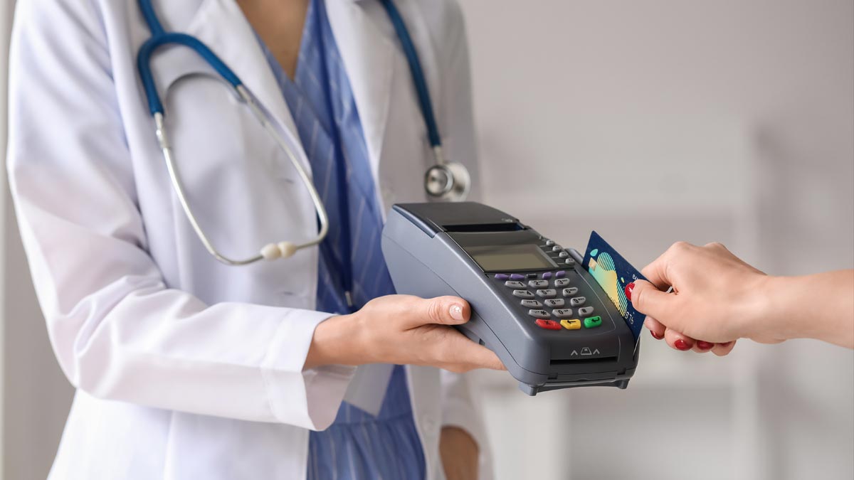Privatmedizin in Österreich: Das stille Sterben des öffentlichen Kassensystems atientin bezahlt Wahlarzt-Rechnung mit Kreditkarte an einem Kartenterminal in einer Arztpraxis. (c) AdobeStock