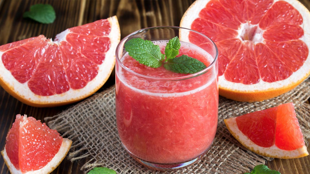 Wechselwirkungen von Medikamenten und Lebensmitteln: Die unsichtbare Gefahr am Teller Frische Grapefruit und ein Glas Grapefruitsaft mit Minzblättern auf einem Holztisch als Symbol für Wechselwirkungen mit Medikamenten. (c) AdobeStock